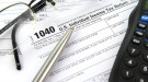 Federal 1040 tax form with a pen, calculator and eyeglasses. 