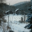 Snowy barns in forest and valley