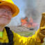 County Forester Regine Skelton giving a thumbs-up in front of a prescribed fire.